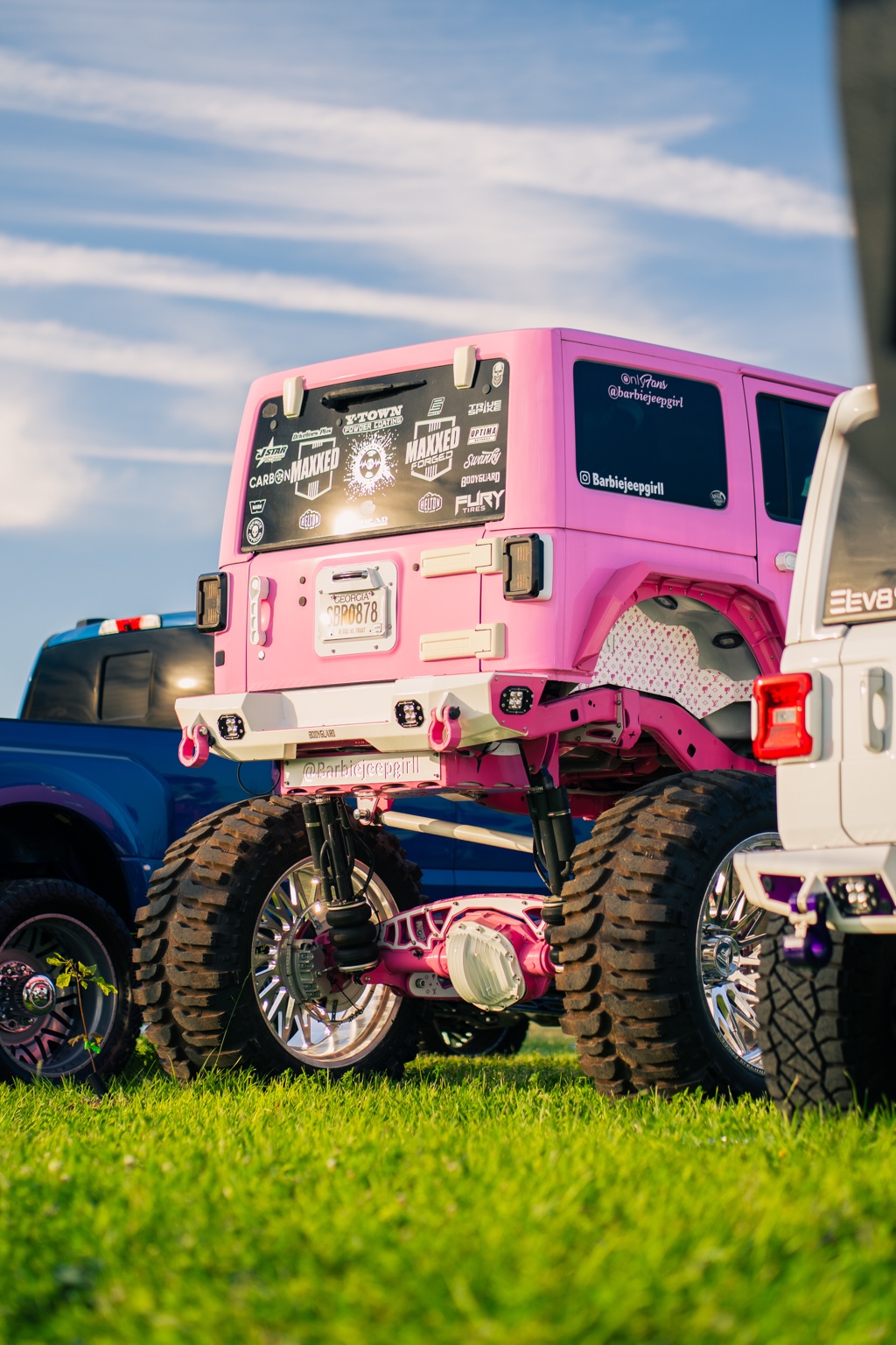 Lifted pink Jeep in a field